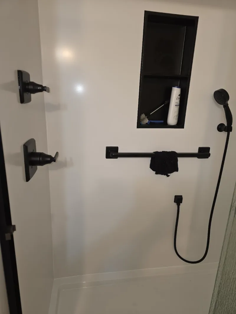 New walk-in shower with black fixtures installed by Yankee Home